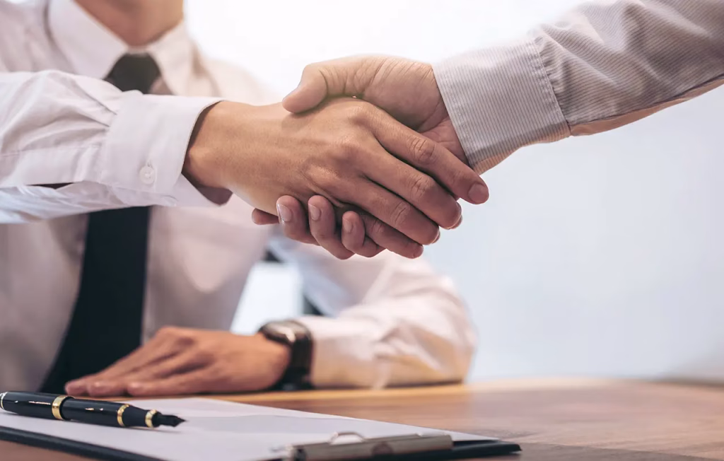 practice-expansion two people shaking hands and sittings at desk